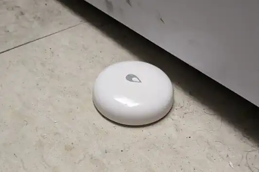 Xiaomi Aqara Smart Water Leak Detector placed under laundry 